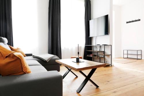 柏林Be in Berlin Apartments im Bergmannkiez的带沙发和咖啡桌的客厅