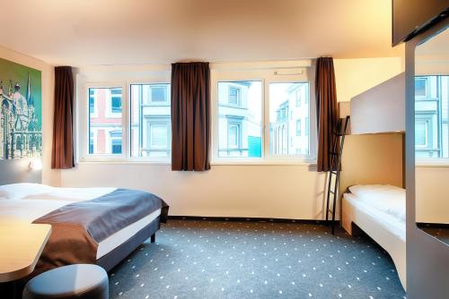 亚琛B&B Hotel Aachen-City的酒店客房带两张床和两个窗户