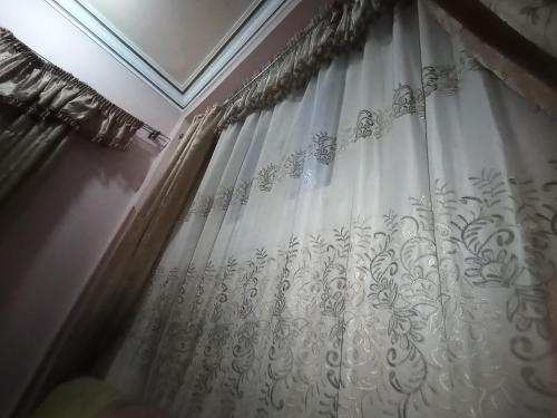 Jazīrat al ‘AwwāmīyahHossam hotil的客房内的白色淋浴帘
