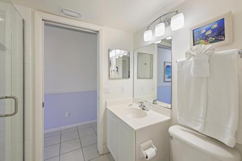 马可岛Beach Club 216的白色的浴室设有水槽和卫生间。