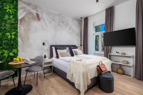 里耶卡Molo Longo - Central Apartments & Rooms的卧室配有一张床和一张桌子及椅子