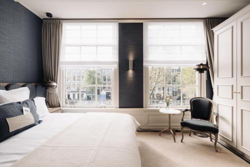 阿姆斯特丹Hotel 717的一间卧室设有一张大床和两个窗户。