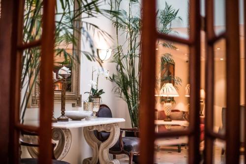 利马Los Tallanes Hotel & Suites的植物间里的桌椅