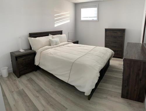 Saint-Félix-d'OtisChalets domaine Otis的一间卧室配有一张带白色床单的大床