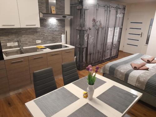 伦达瓦Honey Apartment Lendava的厨房配有两张床和一张鲜花桌