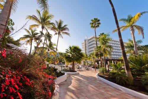 英格兰海滩Hotel Gran Canaria Princess - Adults Only的棕榈树和建筑的走道