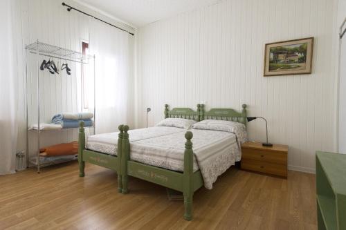 卡奥莱Casa Sincielli的一间卧室设有绿色的床,铺有木地板
