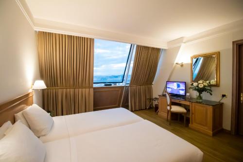 维琴察SHG德拉维尔酒店的酒店客房配有一张床和一张书桌及一台电视