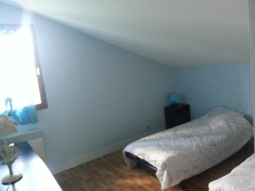 Gîtes à la campagne的一间设有床铺的卧室,位于一间拥有蓝色墙壁的房间