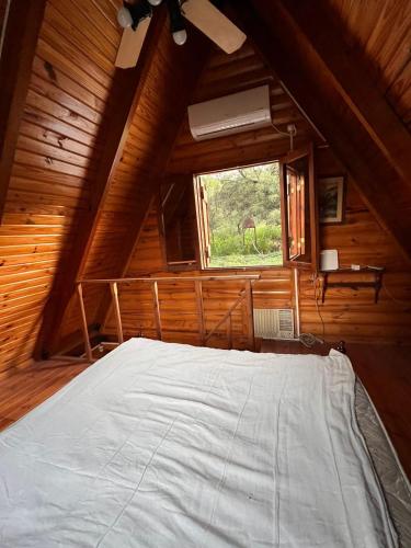 拉里奥哈Cabaña的木制客房的一张床位,设有窗户
