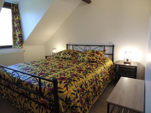Neuville-sur-TouquesLA VILLA QUI A DU CHIEN的一间卧室配有一张带花卉棉被的床