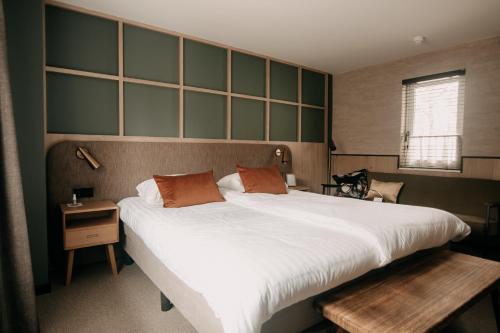 伊皮Witte Berken Natuurhotel的卧室设有一张白色大床和一扇窗户。