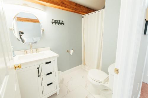 贝塞尔Newly Renovated, Spacious Condo, 3 min to the ski lifts!的一间带水槽、卫生间和镜子的浴室