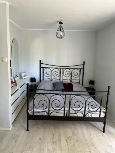 格但斯克Apartament Baltic Sea的一间卧室配有一张黑色的床和吊灯。
