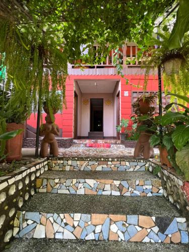蒙特苏马Pura Vida Hostel的一条通往粉红色房子的小路