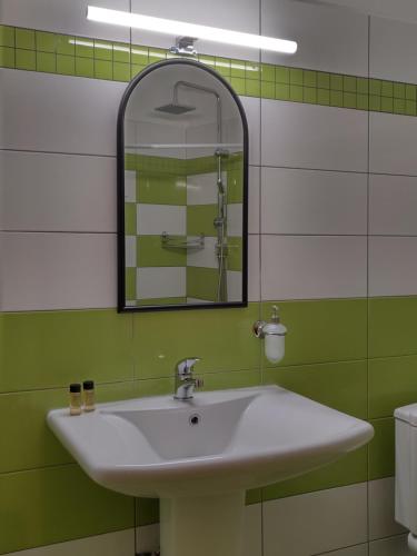 卡兰巴卡利瑟欧斯宾馆的浴室设有白色水槽和镜子