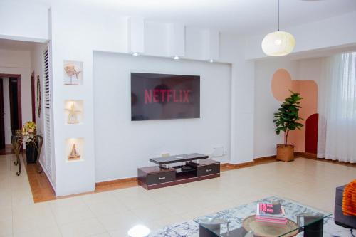 达累斯萨拉姆The Notch的一间客厅,在白色的墙上配有电视