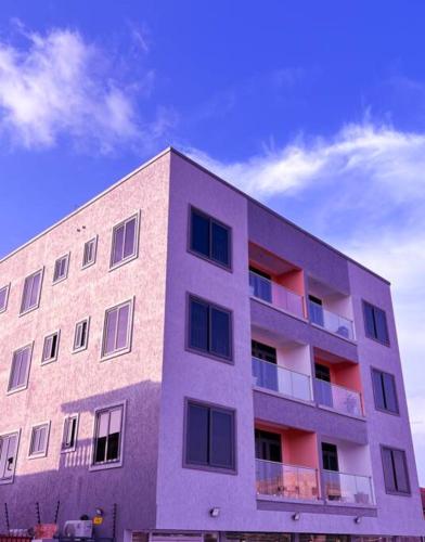 AshaimanRabban Apartment的紫色的建筑,背景是天空