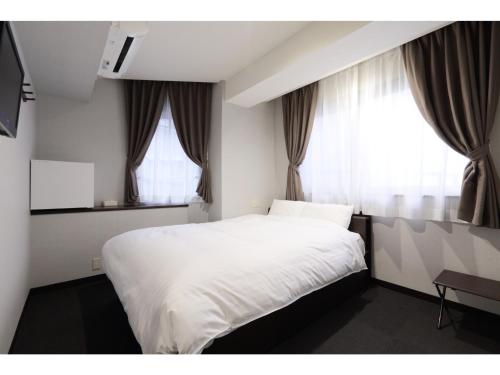 草津Kusatsu Onsen 326 Yamanoyu Hotel - Vacation STAY 10349v的卧室配有白色的床和2扇窗户。