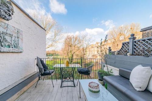 伦敦Elgin Terrace的平台上设有带沙发和桌子的庭院