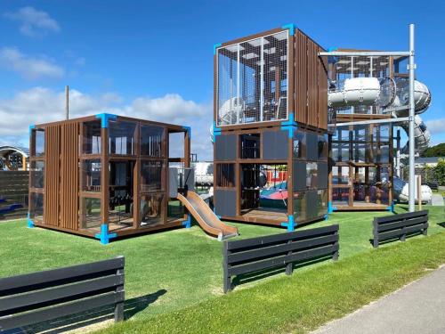 德科赫Beachhouses Texel的草地上设有三个游戏结构的游乐场