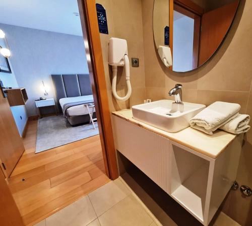 查韦斯阿尔贝加博尔赫斯酒店的一间带水槽和镜子的浴室以及一间卧室
