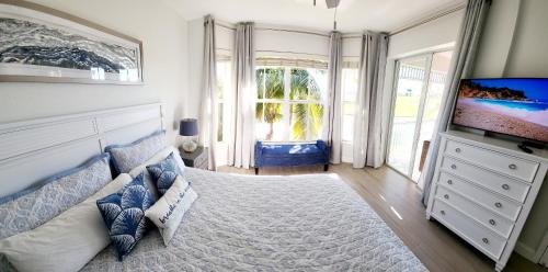 那不勒斯GreenLinks Golf View Villa Flamingo at Lely Resort的一间带大床和电视的卧室