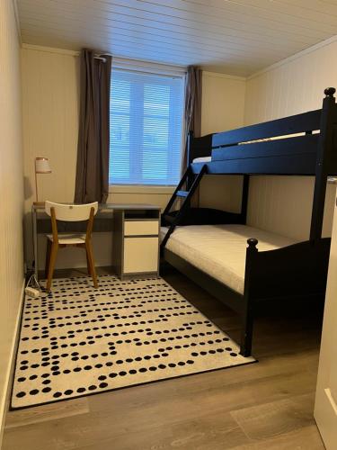 哈尔登New 2 bed room apartment in Halden的一间卧室配有双层床、书桌和椅子