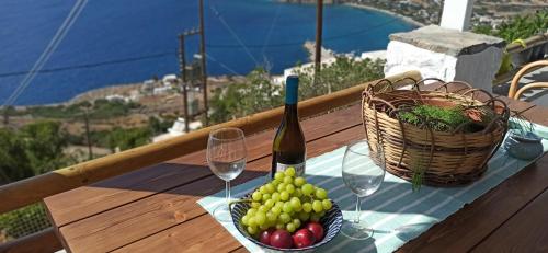 阿莫尔戈斯Idothea guest house的一张桌子,上面放着一篮水果和一瓶葡萄酒