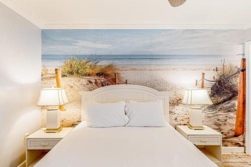 格尔夫海岸Beachview 208的卧室配有一张床,海滩画