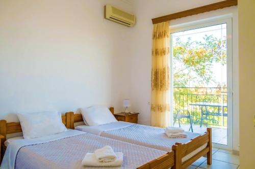 考瑙皮迪亚纳Villa Afroditi in Chania near Airport with Private Pool, Free Wi-Fi, Souda Bay Views, Garden Oasis的一间卧室设有两张床和窗户。