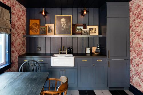大熊湖NP Boutique Lodge的厨房配有蓝色橱柜、水槽和桌子