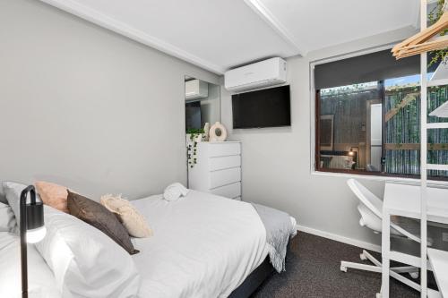 墨尔本Quite, quaint & private guesthouse, sleeps 6的一间卧室配有一张床、一张书桌和一个窗户。