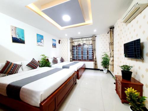 岘港HM Villa - Free Pick-up Mỹ Khê Beach的一间带两张床和电视的大卧室