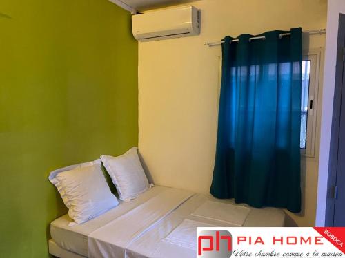 MamoudzouPIA HOME La Pompe的小卧室配有一张带蓝色窗帘的床
