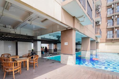 万隆RedLiving Apartemen Tamansari Panoramic - Santuy Agency Lobby P1 9的一座带桌椅的游泳池