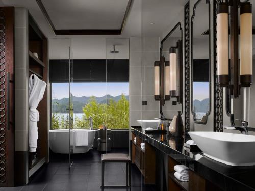 淳安千岛湖安岚酒店的一间带两个盥洗盆、浴缸和窗户的浴室