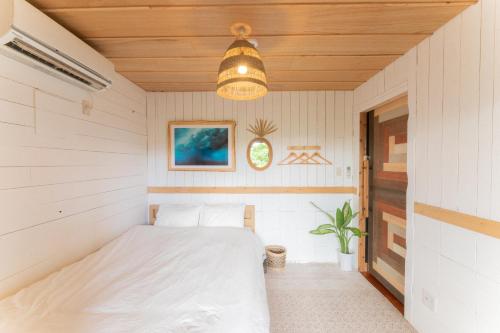本部Mambo Hostel Okinawa的卧室位于房子内,配有床
