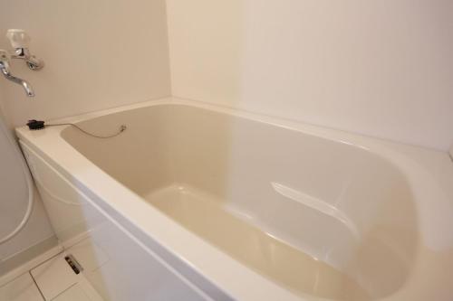 堺市基酒井东公寓酒店 的带白色浴缸的浴室和卫生间