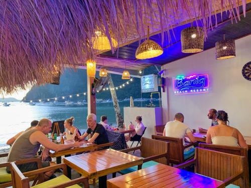 爱妮岛Banig Beach Resort El Nido的一群坐在餐厅桌子上的人