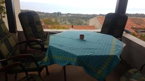 DragozetićiCAPITANO di CHERSO VIP holidays, gourmet & sail experience的阳台上的桌子上放着一杯