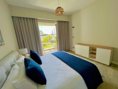 贝尔马尔Tropical beachfront apartment的卧室配有带蓝色枕头的大型白色床