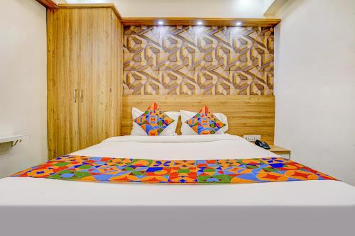 浦那FabHotel Galaxy Stay的一间卧室配有一张大床和木制床头板