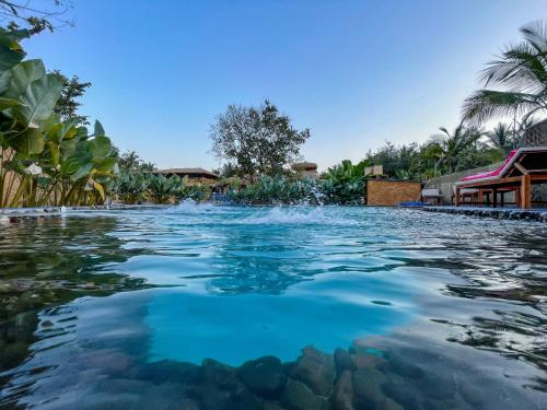 卡纳科纳One At Goa的度假村内的一个蓝色海水游泳池