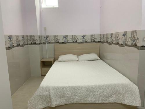 绥和市gau homestay的卧室配有白色的床和窗户。