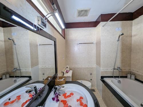 胡志明市Đông Kinh Hotel的带浴缸、水槽、浴缸和卫生间的浴室。