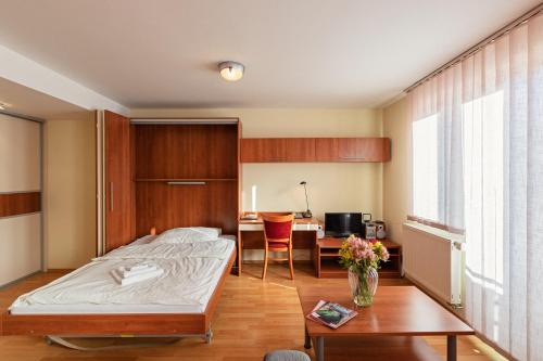 班斯卡-比斯特里察尔彬城市公寓式酒店的一间卧室配有一张床、一张桌子和一张桌子