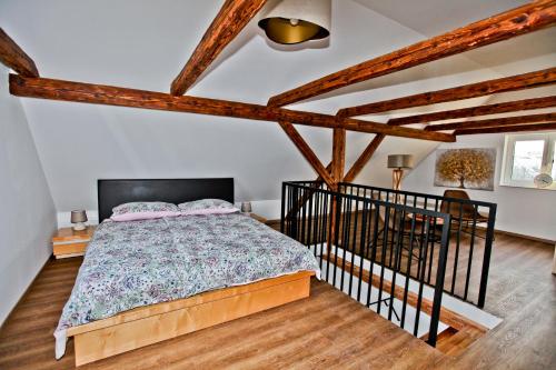Zgornja KungotaVila Loni的卧室配有一张床铺,位于带木梁的房间