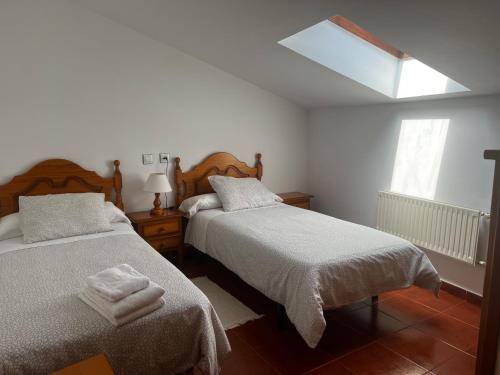 San Juan de ParresCamín de la reina的一间卧室设有两张床和天窗
