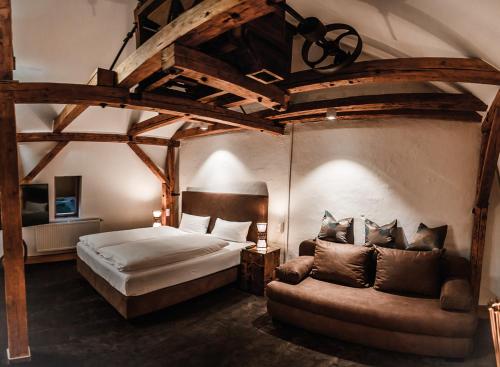 阿尔岑瑙·因·尤特弗兰恩Landhotel Kahltalmühle的一间卧室配有一张床和一张沙发